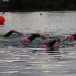Triathletes practising their open water swimming and front crawl for triathlon
