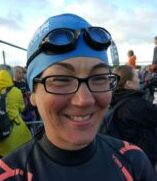 Coach Penny in her wetsuit, swim hat and goggles ready for Ironman Triathlon